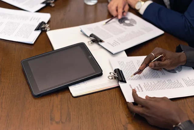 A business meeting with tablets and documents, showcasing digital integration in a professional setting. Media buying agencies operations: campaign governance guide
